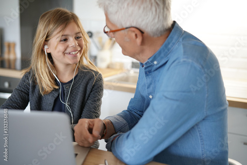 Father and child at home doing online school teaching class