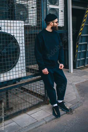 Wallpaper Mural City portrait of handsome hipster guy with beard wearing black blank hoody or sweatshirt and hat with space for your logo or design. Mockup for print Torontodigital.ca