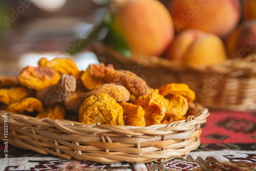 Dried fruts and Fresh peaches fruits with leaves in basket on rustic background photo