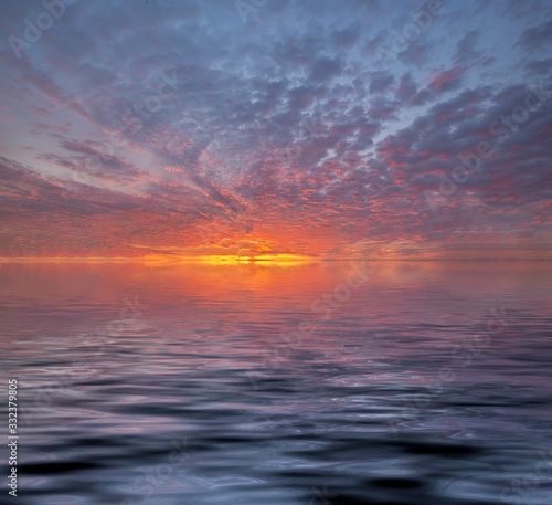 View of sunset into the ocean with twilight sky. Fiery orange sunset sky. Beautiful sky © funfunphoto