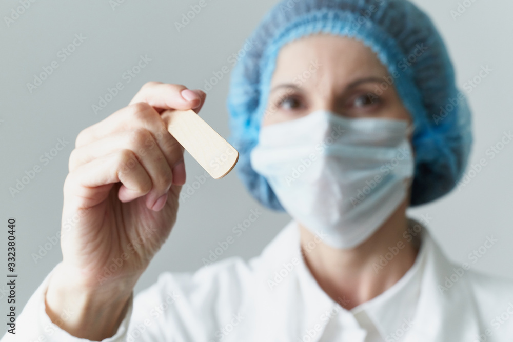 Female doctor in medical mask and uniform check up condition of throat. Illness protection,