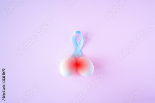 prostate cancer, healthcare, profession, medicine concept - close up of chicken white eggs and blue ribbon with hurt red signs on bright background. Cancer awareness, cure, men carcinoma