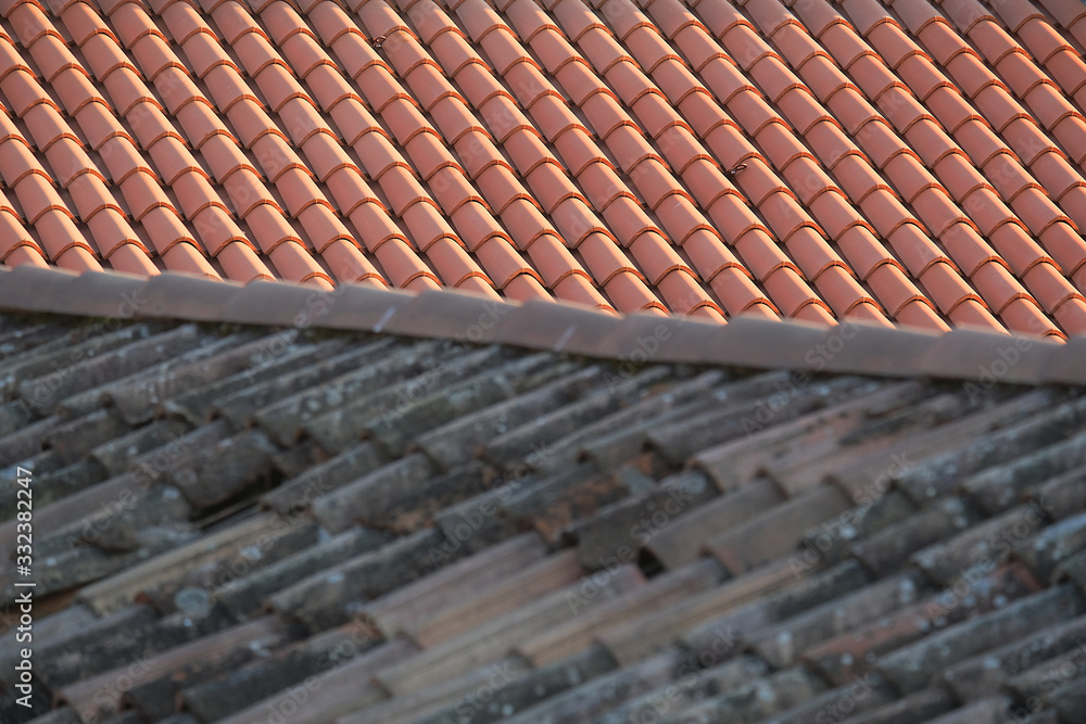 Fototapeta premium Old and new roof tiles of a building