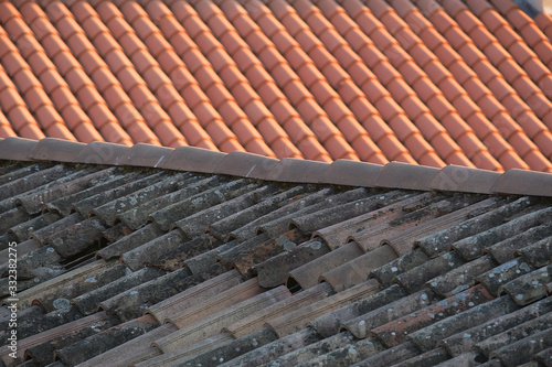 Old and new roof tiles of a building