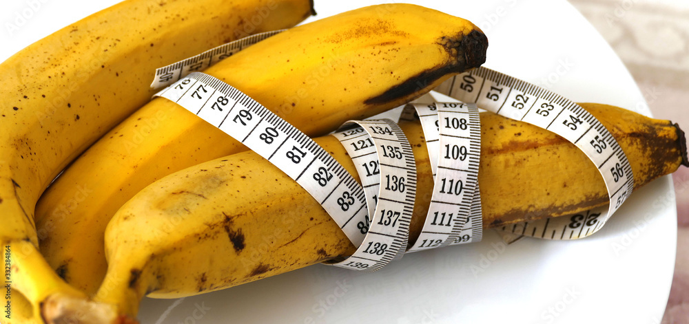 Banana and healthy weight loss, banana and diet, with tape measure on white background, Banana and healthy weight loss, banana and diet, with tape measure on white background,