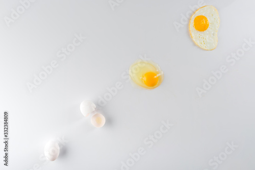 top view of eggs transformation phases from raw to fried on white