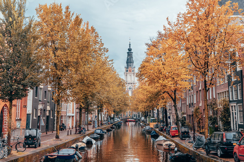Autumn on a canal in Amsterdam with clock tower in background.