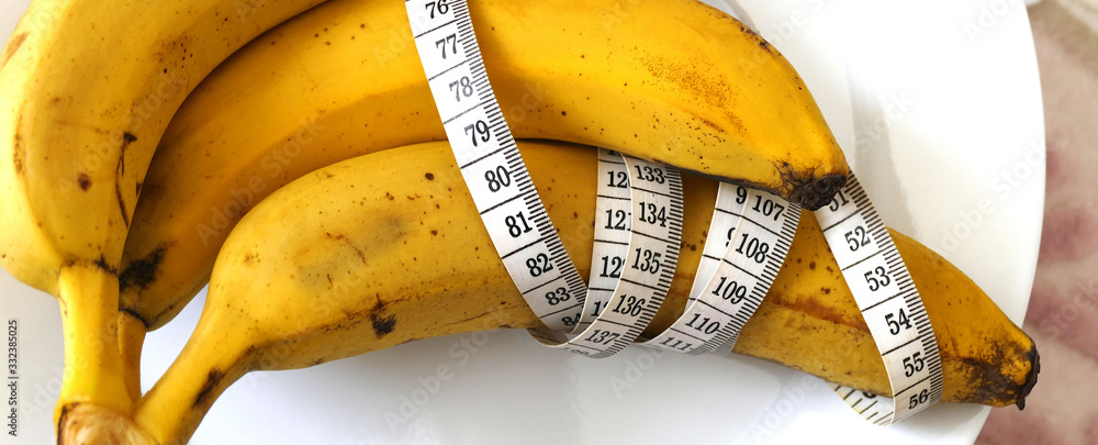 Banana and healthy weight loss, banana and diet, with tape measure on white background, Banana and healthy weight loss, banana and diet, with tape measure on white background,