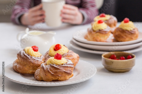 Italian pastry - zeppole di San Giuseppe - baked cream puffs made from choux pastry  filled and decorated with custard cream and cherry. Eaten to celebrate Saint Joseph s Day.