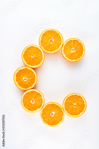 Quadro su tela Halved orange slices designed as letter c representing vitamin c  on white backg
