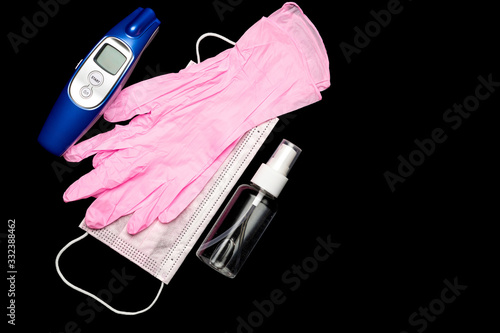 Medical gloves surgical mask, sanitizer gel, modern thermometer - Virus protection equipment on black background. China pathogen respiratory coronavirus 2019-ncov flu outbreak medical concept photo