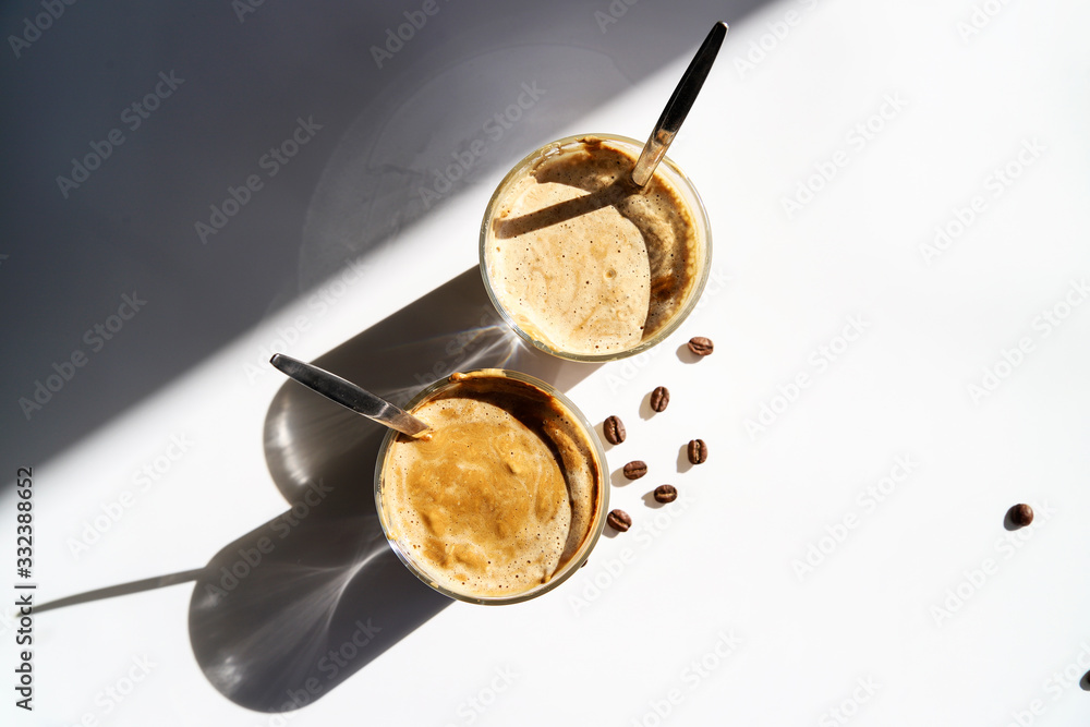 Cold coffee – latte, cappuccino or dalgona. Summer trendy drink with whipped milk, top view Cold coffee – latte, cappuccino or dalgona. Summer trendy drink with whipped milk, top view