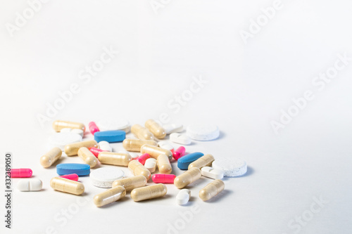 Medicine, virus treatment. Coronavirus vaccine, Covid19. Capsules and pills pink and blue, white background Pandemic medicine.