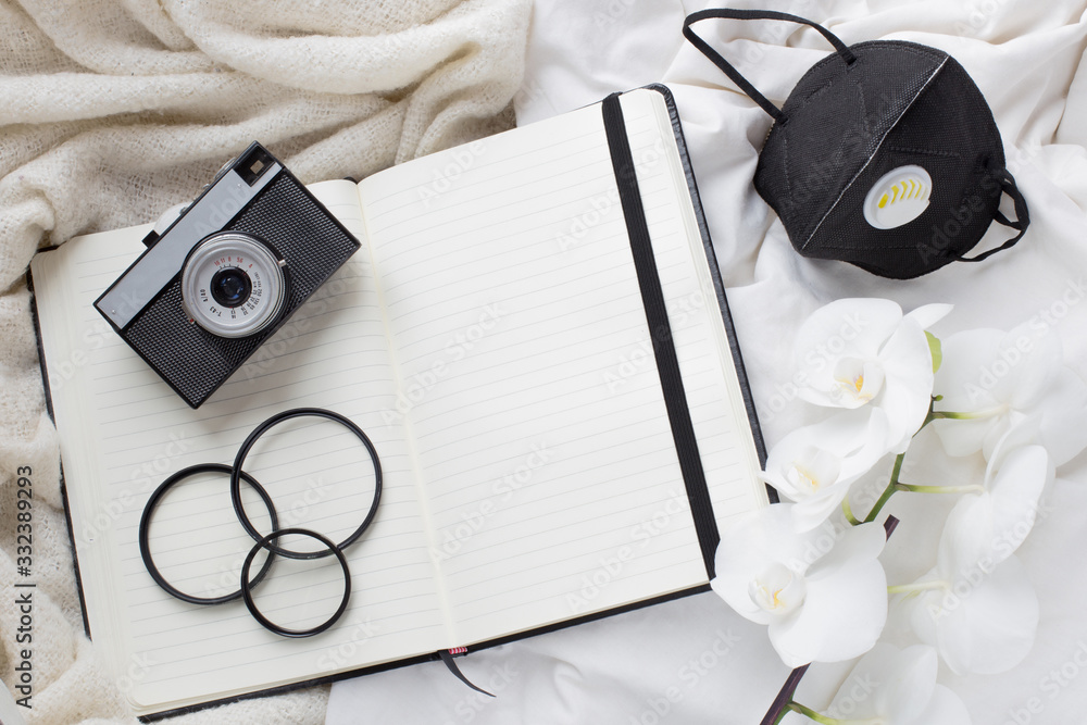 time of isolation, illness. camera, notebook and protective mask. stay at home. photographer's work during quarantine. quarantine and photography.