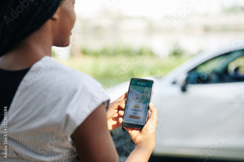 Obraz w ramie Female driver accepting new request in car sharing application, selective focus