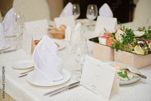 Table set with blank guest card, plate with serviette and cutlery on table, copy space. Place setting at wedding reception. Table served for wedding banquet in restaurant © mirage_studio