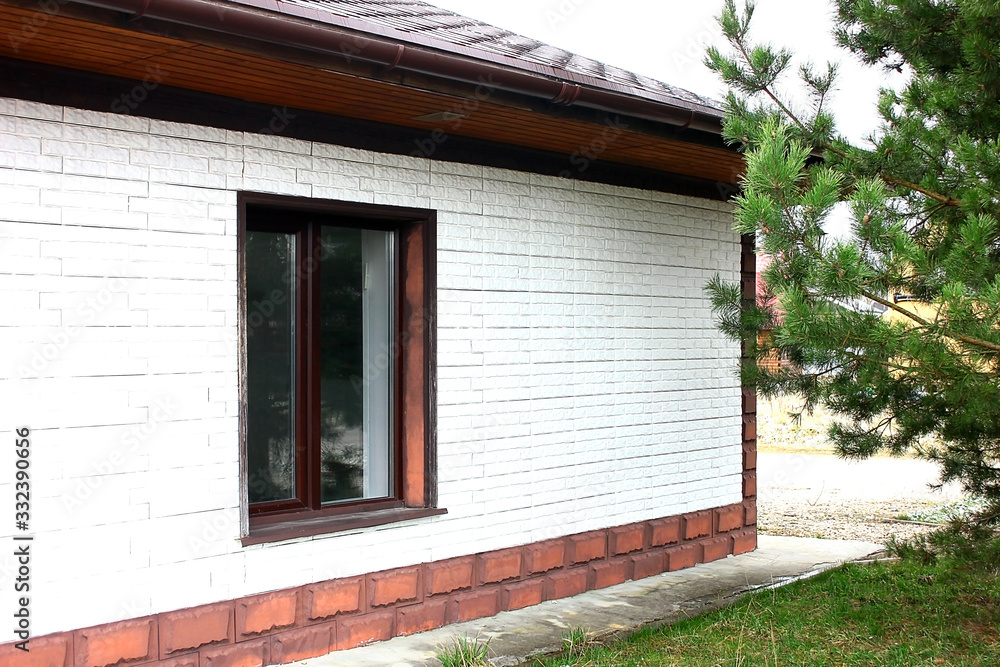 A small one-story white brick house, among pine trees in a landscaped garden. Good summer weather. A small one-story white brick house, among pine trees in a landscaped garden. Good summer weather.