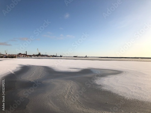 Lighthouse and pier at sunset in the city of Kronstadt in winter. Saint-Petersburg.
