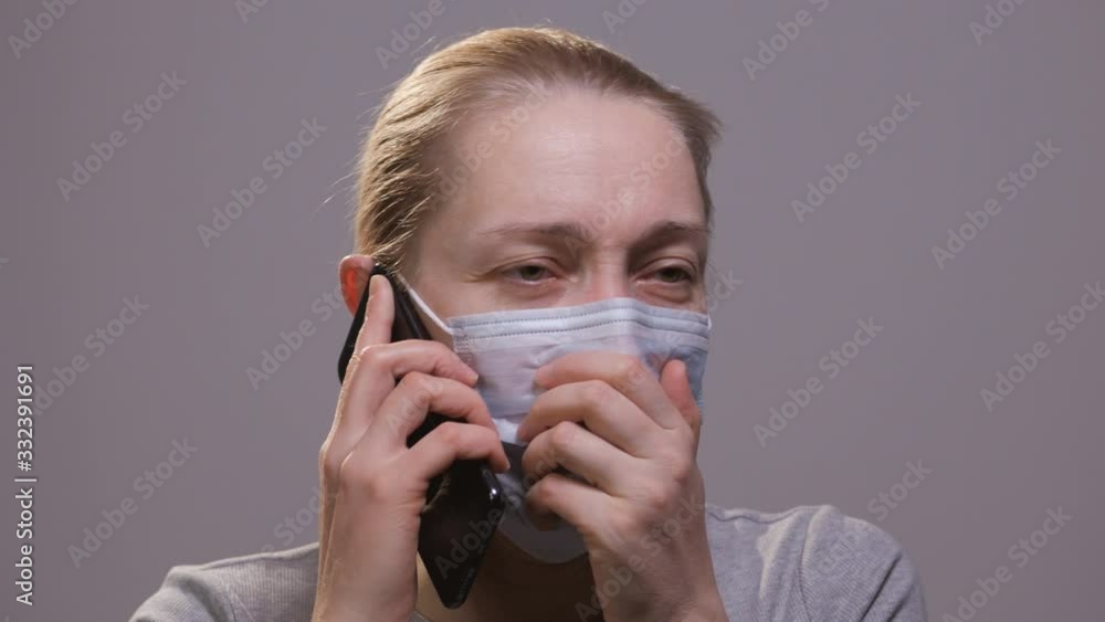 A woman in a medical mask on her face is talking on the phone. A woman in a medical mask on her face is talking on the phone.
