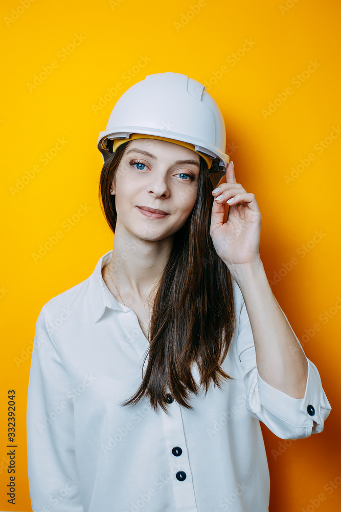 Woman engineer in white helmet. Safety poster. Woman in white shirt touches helmet. Woman engineer in white helmet. Safety poster. Woman in white shirt touches helmet.