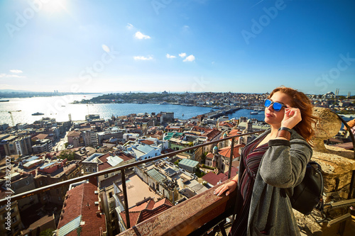 A beautiful girl tourist enjoying the view of  historical center of Istanbul from the top of the Galata Tower