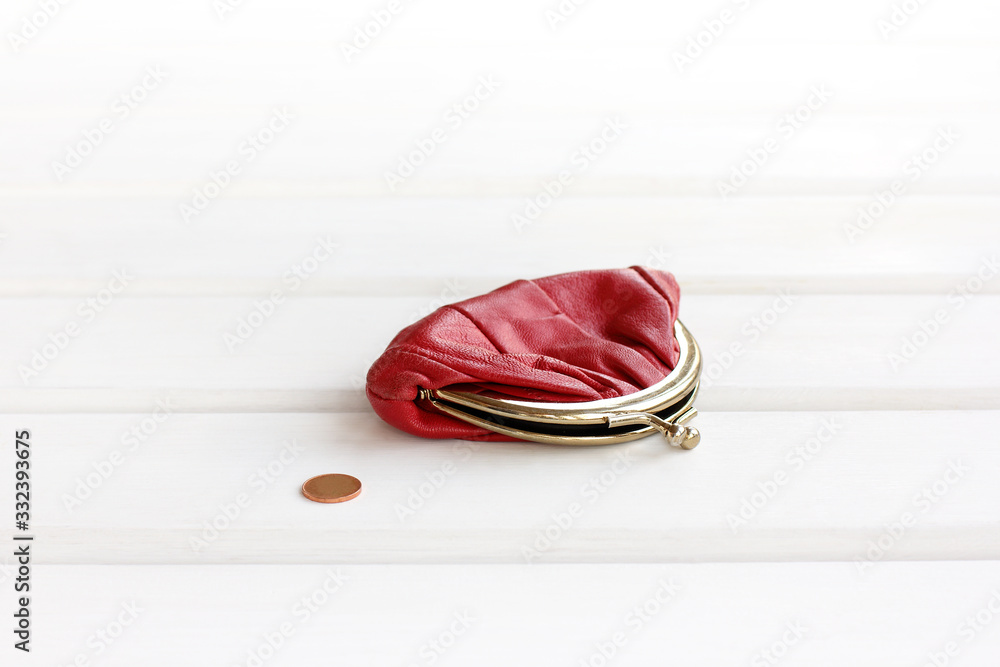the smallest coin next to the red wallet on the table. cash shortfall the smallest coin next to the red wallet on the table. cash shortfall