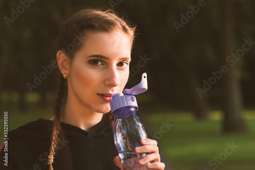 Beautiful young caucasian woman in fitness wear working out in a park.