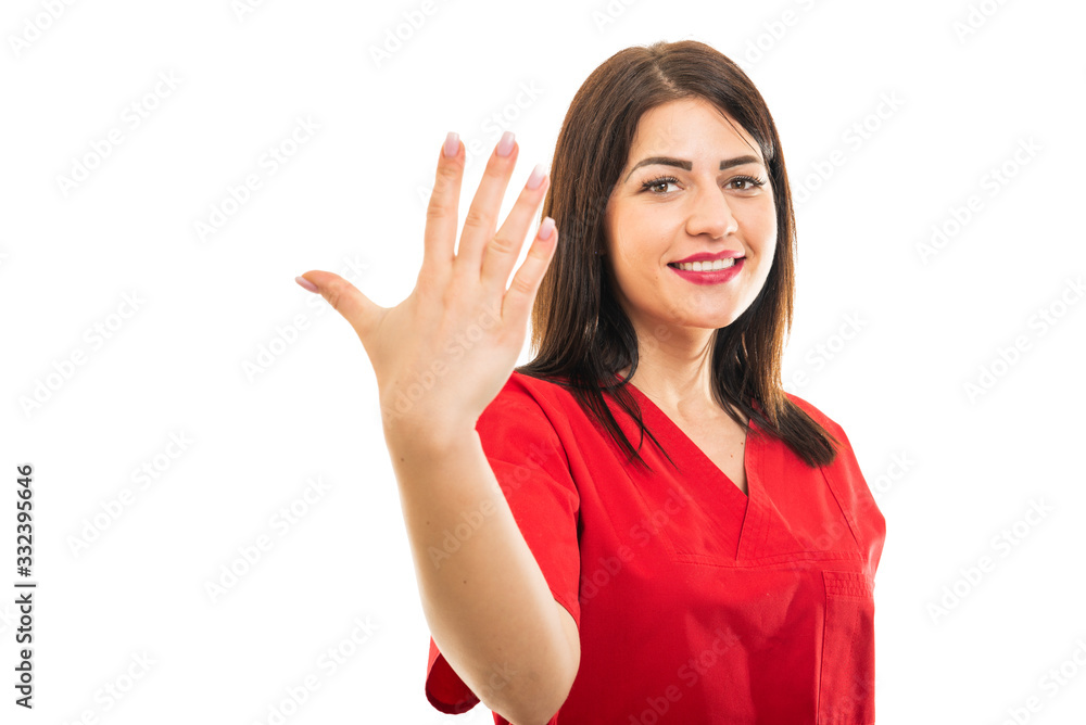 Portrait of beautiful young doctor wearing scrubs showing number five Portrait of beautiful young doctor wearing scrubs showing number five
