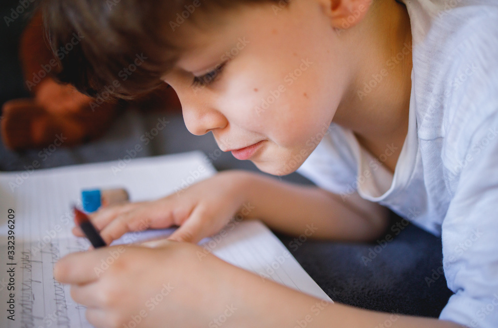 Boy doing Homework while Lying in Bed Boy doing Homework while Lying in Bed