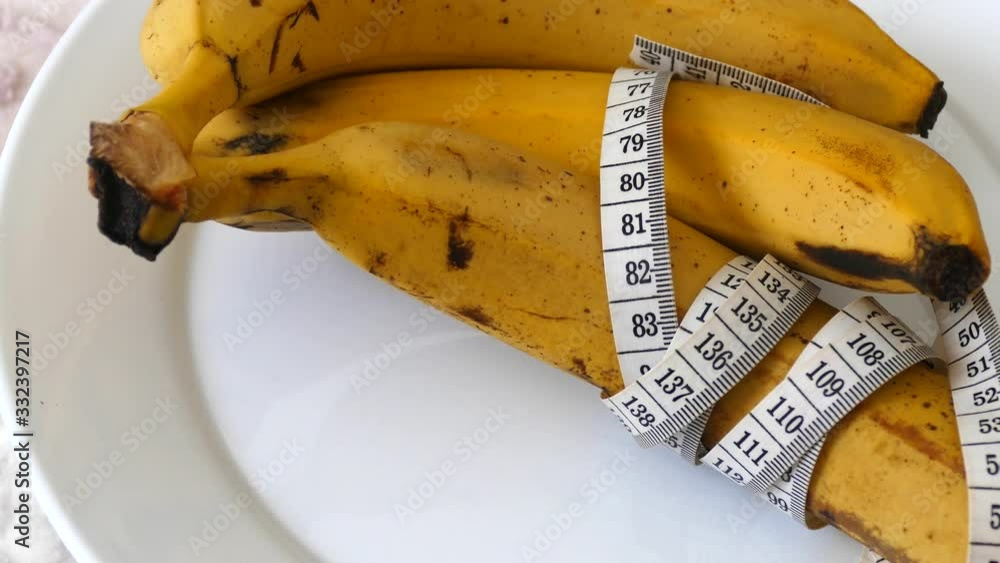 Banana and healthy weight loss, banana and diet, with tape measure on white background, Banana and healthy weight loss, banana and diet, with tape measure on white background,