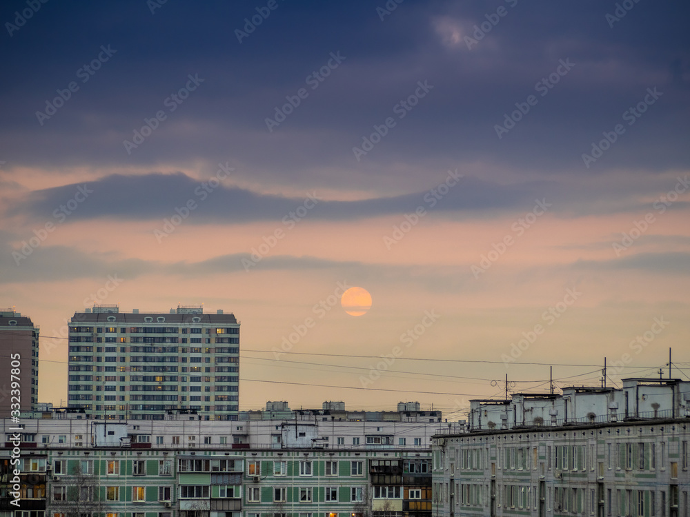 Cloudy sky with rising moon over apartment buildings of the urban district. Panorama of the cityscape after dusk. Moscow city, Russia. Looks like watercolor painting. Cloudy sky with rising moon over apartment buildings of the urban district. Panorama of the cityscape after dusk. Moscow city, Russia. Looks like watercolor painting.
