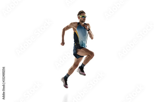 Triathlon male athlete running isolated on white studio background. Caucasian fit jogger, triathlete training wearing sports equipment. Concept of healthy lifestyle, sport, action, motion. Side view. © master1305