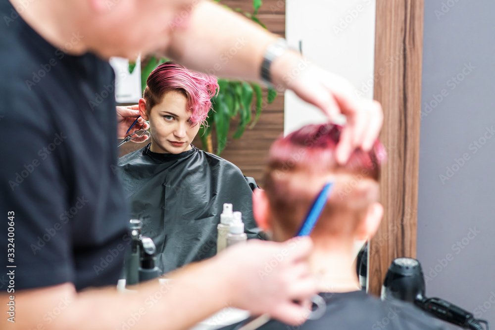 Hairdresser combs hair.