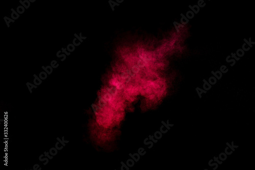 Red and pink powder explosion on black background. Colored powder cloud. Colorful dust explode. Paint Holi.