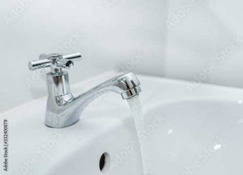 Close up water flowing faucet with on bathroom