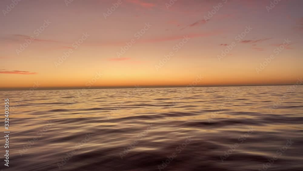 Calm ocean sunset orange sky reflecting on the water Calm ocean sunset orange sky reflecting on the water