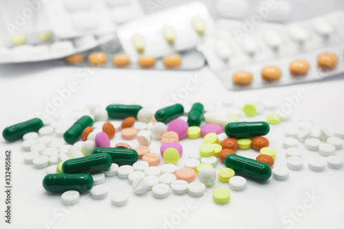 The concept of pills for treatment. Multi-colored white,  yellow, orange, green, pink tablets on a white isolate background . Copy space. 