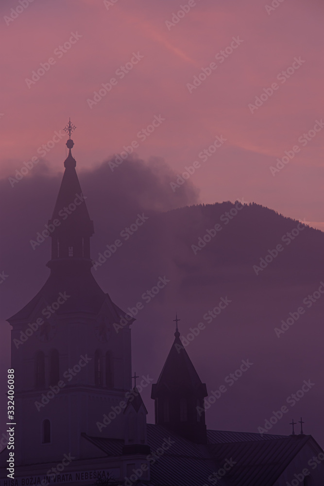 Church covered in mist with sunlit cloud, Bohinj