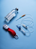 glass medicine bottle with syringe injection, dropper system on blue background isolation. Close-up of an infusion system with an infusion containing a syringe containing blue liquid against a light 