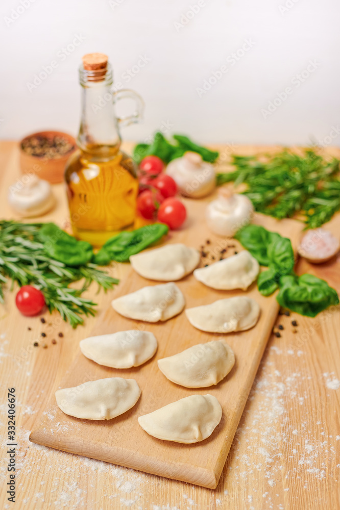 Dumplings on a wooden board with vegetables Dumplings on a wooden board with vegetables