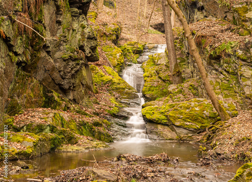 waterfall cascade between rocks in forest near stribro, long exposure