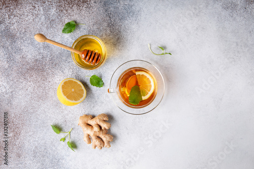 Cup of hot tea with ginger  lemon mint and honey on concrete background. Top view. Copy space.