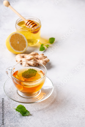 Cup of hot tea with ginger, lemon,mint and honey on concrete background.