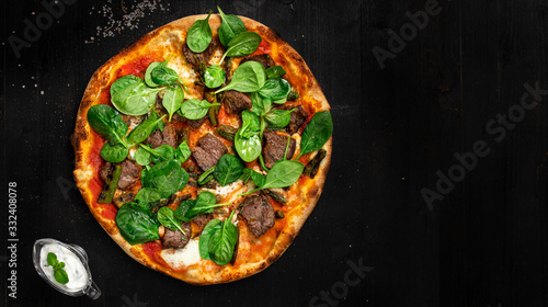Tasty italian pizza with beed and baby spinach made from an authentic recipe. Mozzarella topping mealted on top. Sauce aside. Professional product photography and lightning.