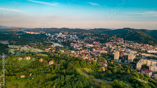 Fototapeta Naklejka Na Ścianę i Meble -  Aerial view of downtown Tuzla at sunset, Bosnia. City photographed by drone, traffic and objects , landscape.city photographed from air by drone.Old balkan buildings and communism type of architecture