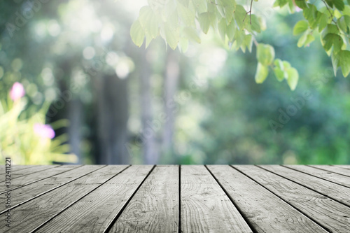Wooden desk and blurred garden green nature background.