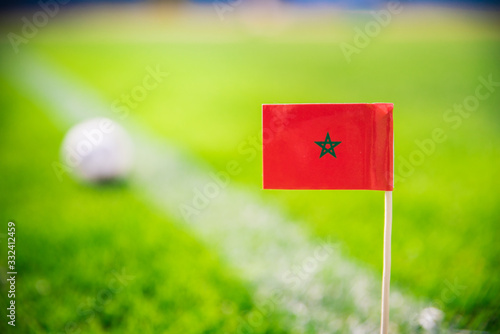 Morocco national Flag and football ball on green grass. Fans, support photo, edit space
