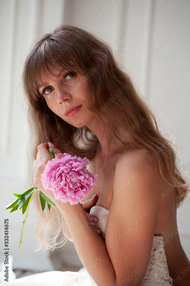 Spring Woman. Beauty Summer model girl. Beautiful Lady with pink peony on her hand. Nature Hairstyle. Natural Makeup. Spring Woman. Beauty Summer model girl. Beautiful Lady with pink peony on her hand. Nature Hairstyle. Natural Makeup.
