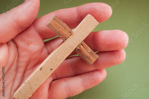 Hand holds wooden cross, easter day, world prayer day, international prayer day