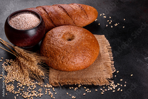 Fresh baked brown bread on a brown concrete background